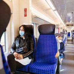Fahrgäste mit Maske im Zug