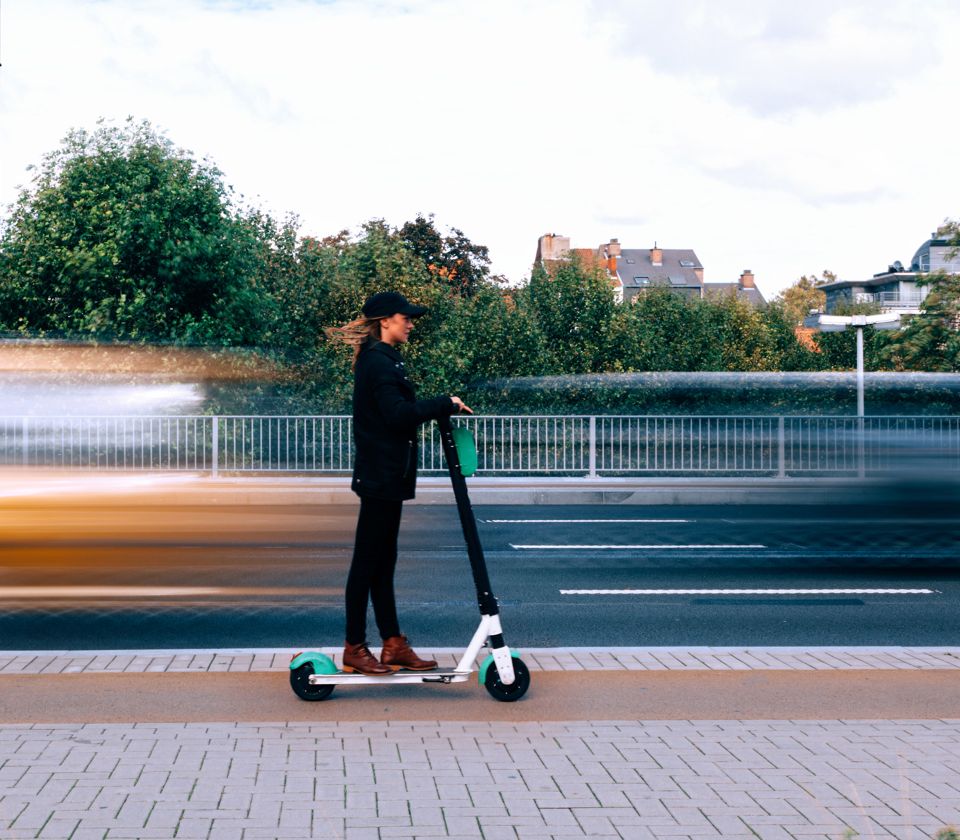 Eine junge Frau unterwegs auf einem Elektroroller