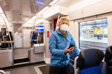 Fahrgast mit Maske im Zug