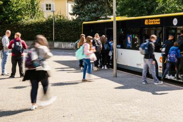 Personenen steigen in einen Bus