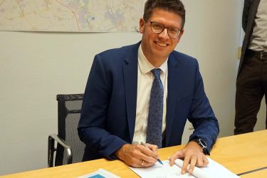 Bürgermeister Stephan Muckel unterzeichnet die Rahmenvereinbarung.