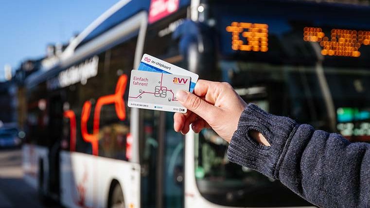 Fahrgast mit Chipkarten vor einem Bus